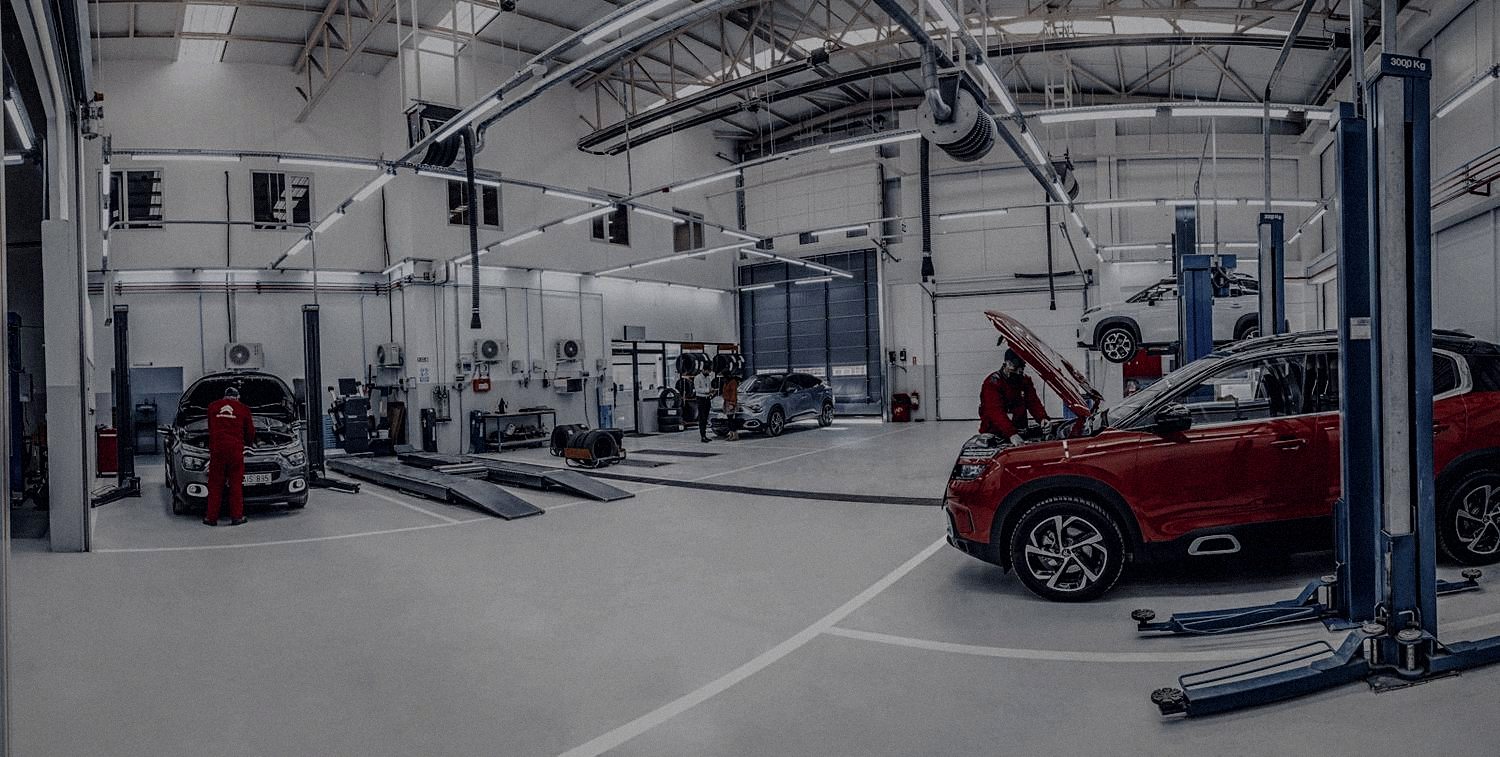 A modern multi-bay automotive workshop with hydraulic lifts, tyre bays and an epoxy floor